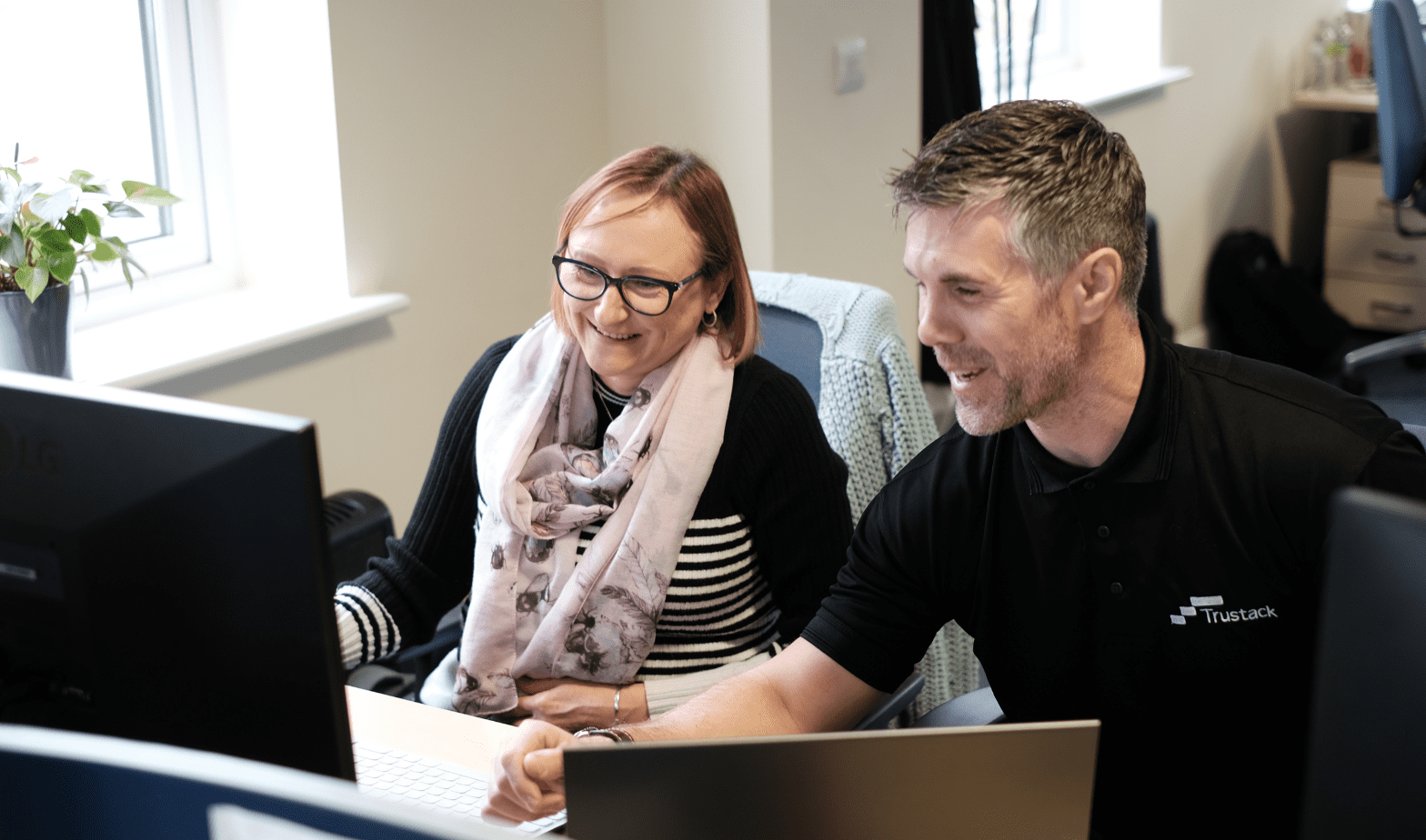 Two Trustack employees laughing in the office