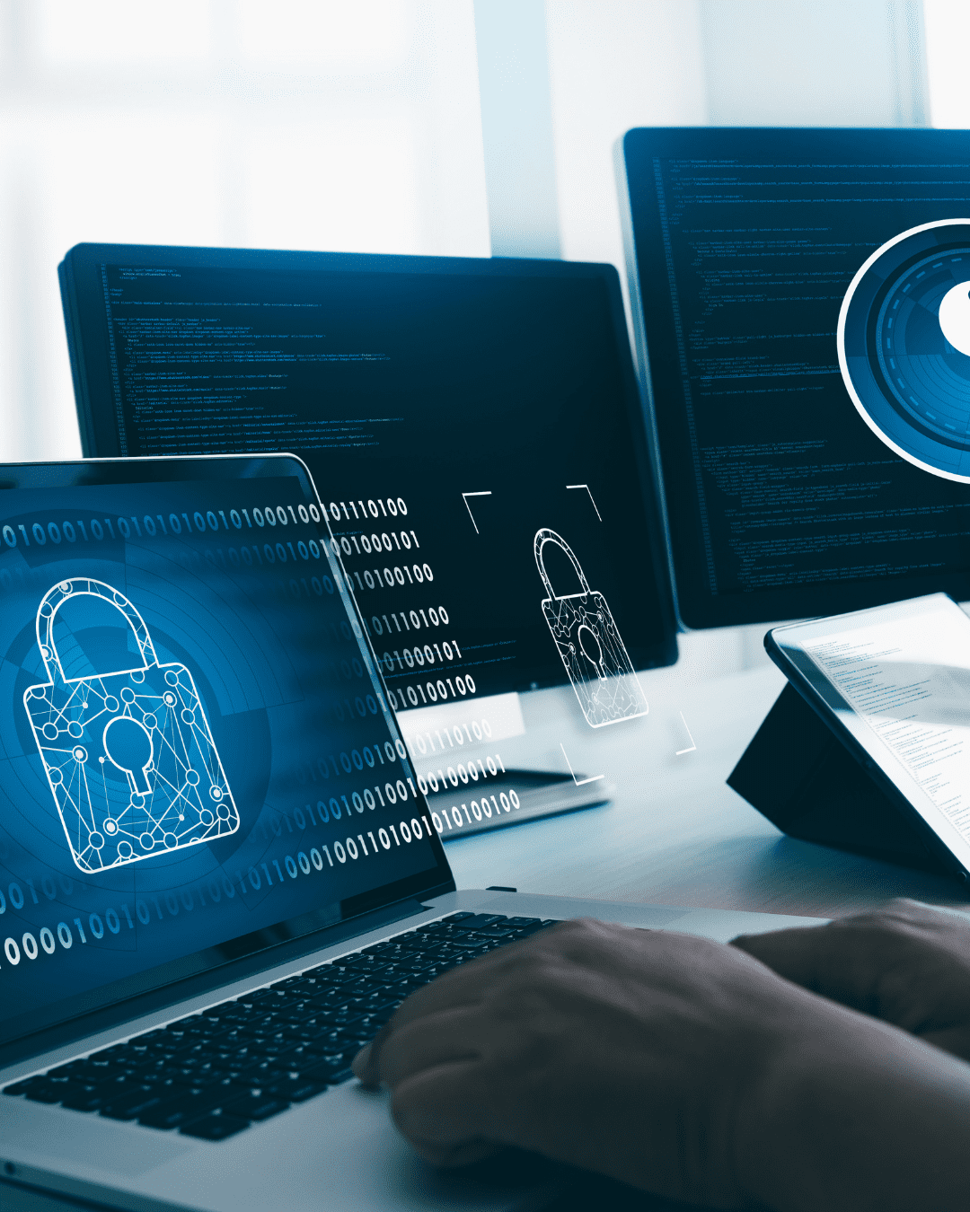 Trustack MSP Cyber Security, IT Services, IT Support. Three computer screens display digital lock icons and binary code, suggesting cybersecurity themes and hinting at what a Security Information and Event Management (SIEM) system monitors. A person's hands are visible typing on a laptop keyboard in the foreground, set in a modern office environment. SIEM Image