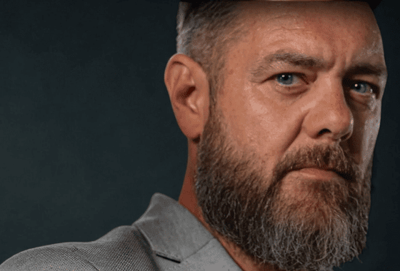 Trustack MSP Cyber Security, IT Services, IT Support. A middle-aged man with blue eyes and a full grey beard wearing a grey blazer, looking slightly to the side against a dark background.