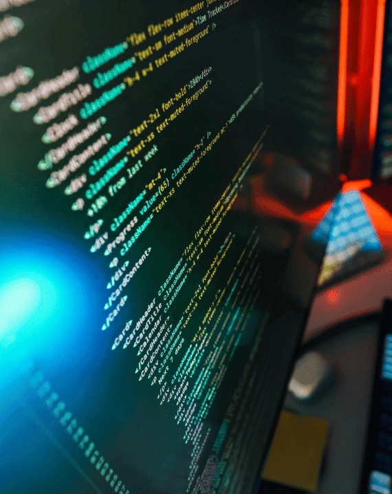 Trustack MSP Cyber Security, IT Services, IT Support. A close-up of a computer screen displaying lines of colourful code in a text editor, highlighting cyber security essentials, with a blurred keyboard and blue light reflection visible in the background.