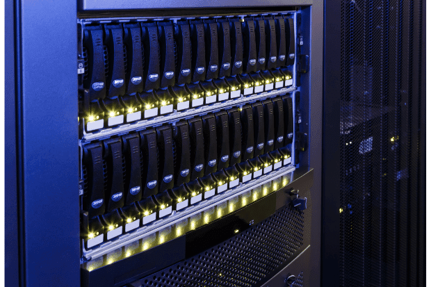 Trustack MSP Cyber Security, IT Services, IT Support. Close-up view of server racks filled with multiple hard drives in a data centre, showcasing rows of black drives with indicator lights illuminated—ideal for secure server hosting and colocation services.